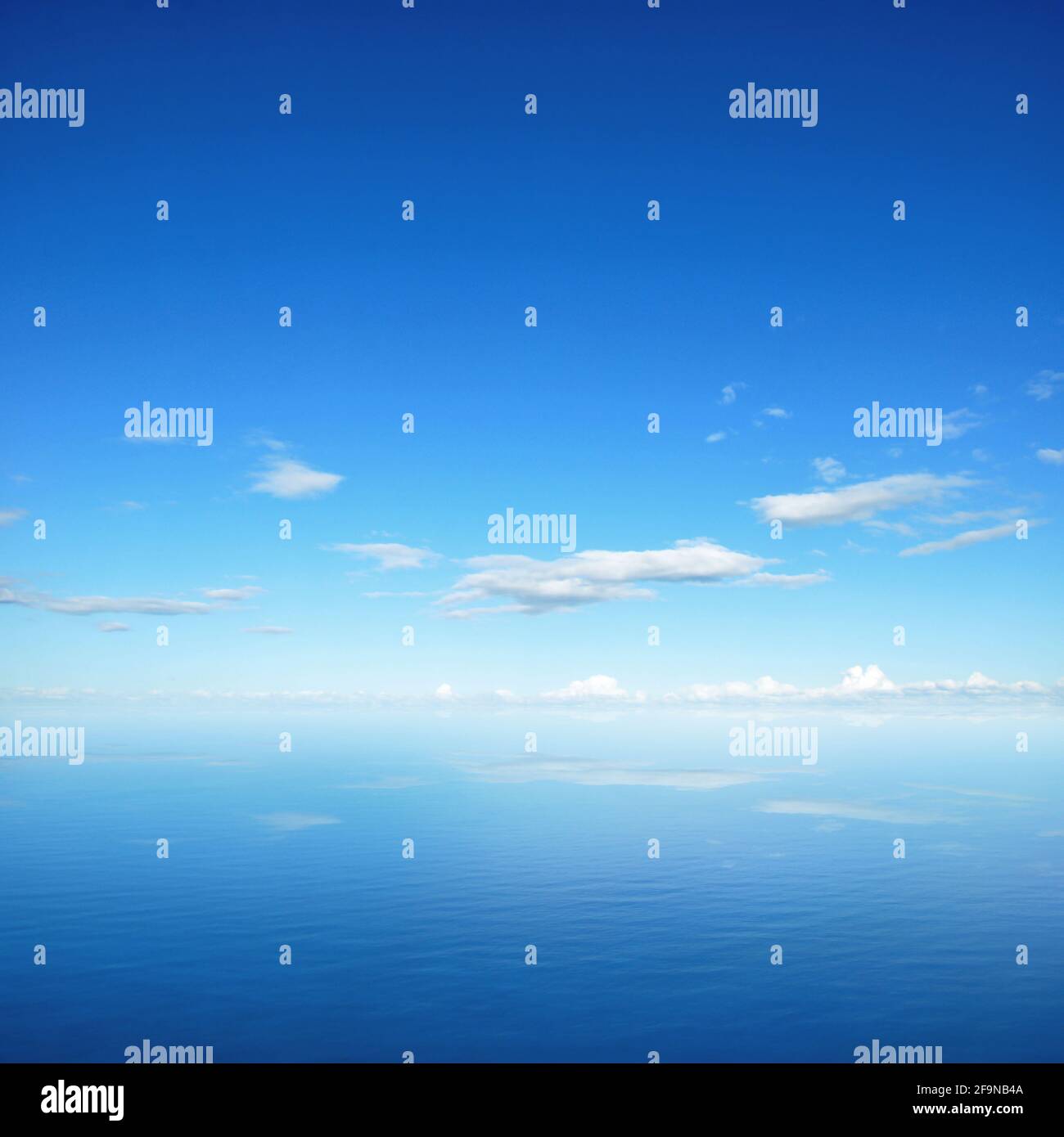 Ciel bleu et nuages avec réflexion sur l'eau de mer Banque D'Images