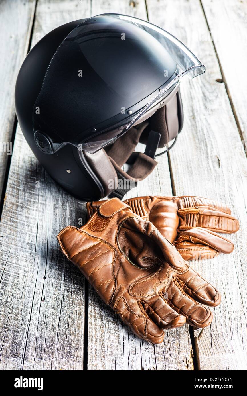 Accessoires de sécurité pour moto. Gants en cuir et casque sur table en bois. Banque D'Images