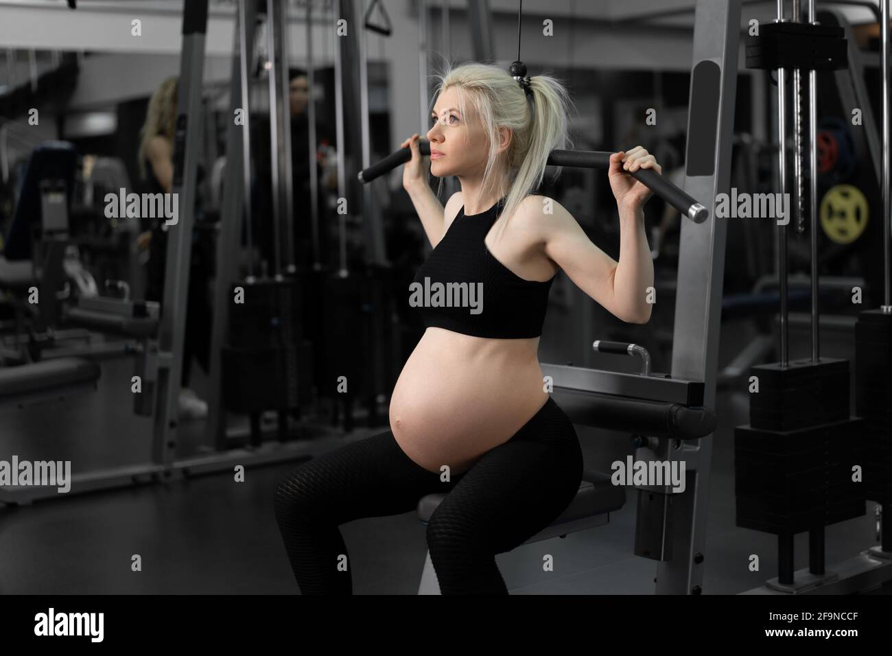 Gym entraînement femme enceinte sportswear entraînement épaules avec  machine d'exercice beau temps de grossesse. Style de vie sain Sport et  concept de forme physique Photo Stock - Alamy