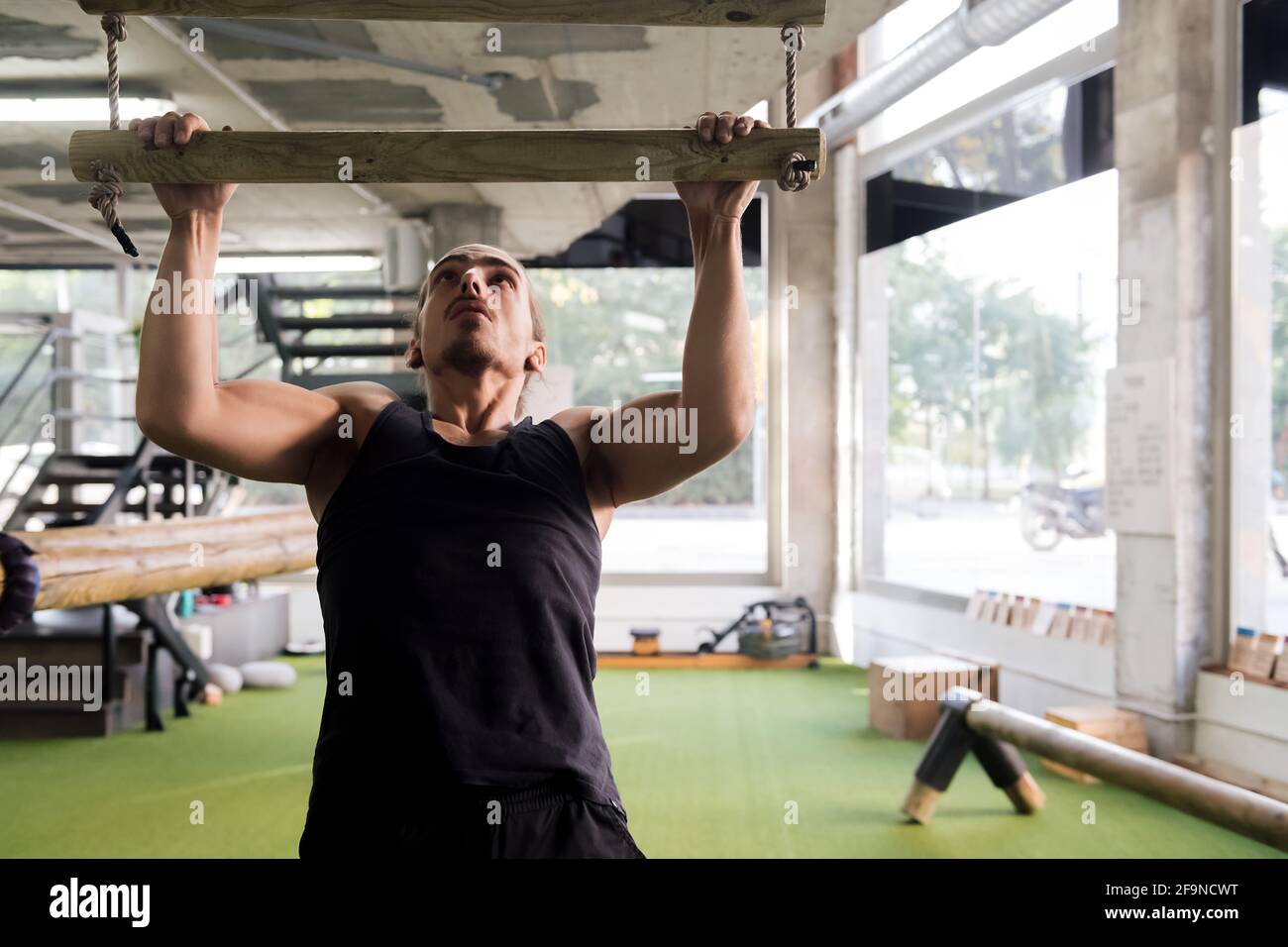 jeune homme entraînement de force faire des pull-ups à la salle de gym, active et sportif concept de style de vie, copyspace pour le texte Banque D'Images