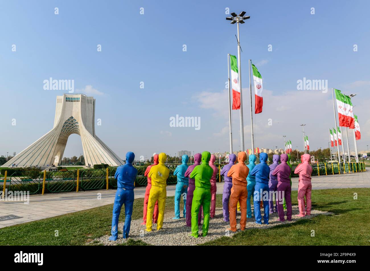 Groupe de copies peintes d'un homme regardant la Tour Azadi à Téhéran, Iran. Banque D'Images