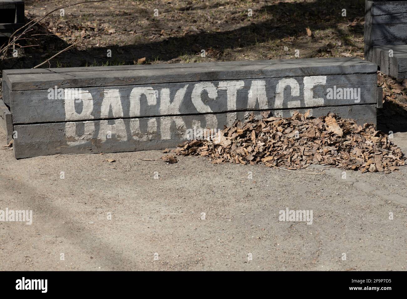 Banc bas sombre avec l'inscription « Backstage » avec un tas de feuilles mortes sèches Banque D'Images