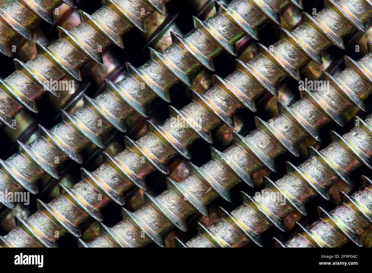 Vis à tôle en laiton d'or galvanisées avec fond de fond de macro ornemental à lignes teintées diagonales, diagonales, obliques, inclinées, obliques Banque D'Images
