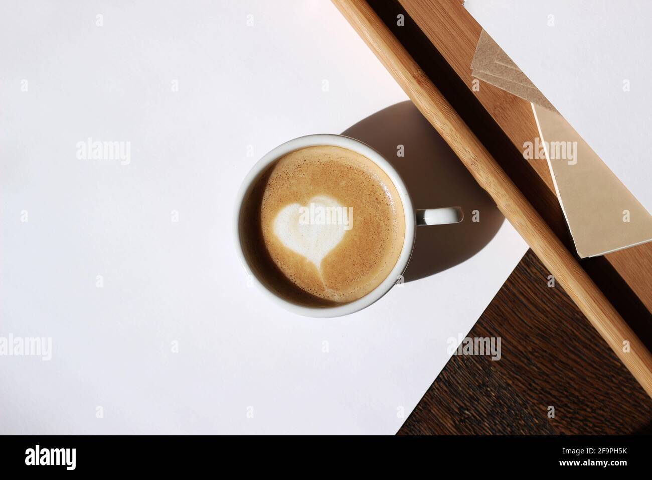 Au-dessus du Cappuccino avec Heart Latte Art sur le bureau à domicile. Vue sur le plateau du café. Banque D'Images