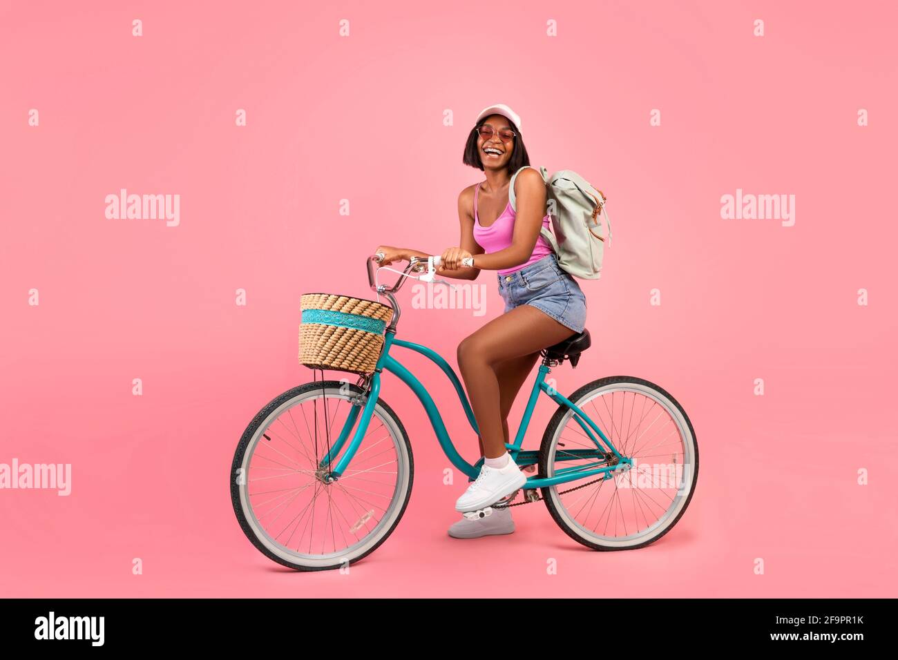Portrait complet de femme noire charmante en été décontracté vêtements à vélo  sur fond de studio rose Photo Stock - Alamy