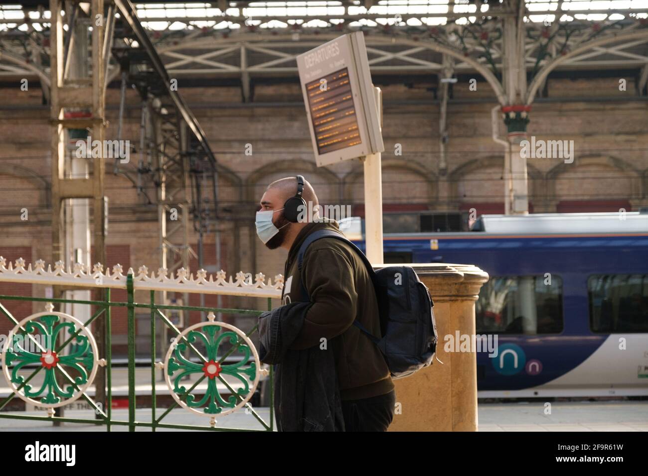 Un passager portant un masque facial et un casque quitte la gare de Preston. Banque D'Images