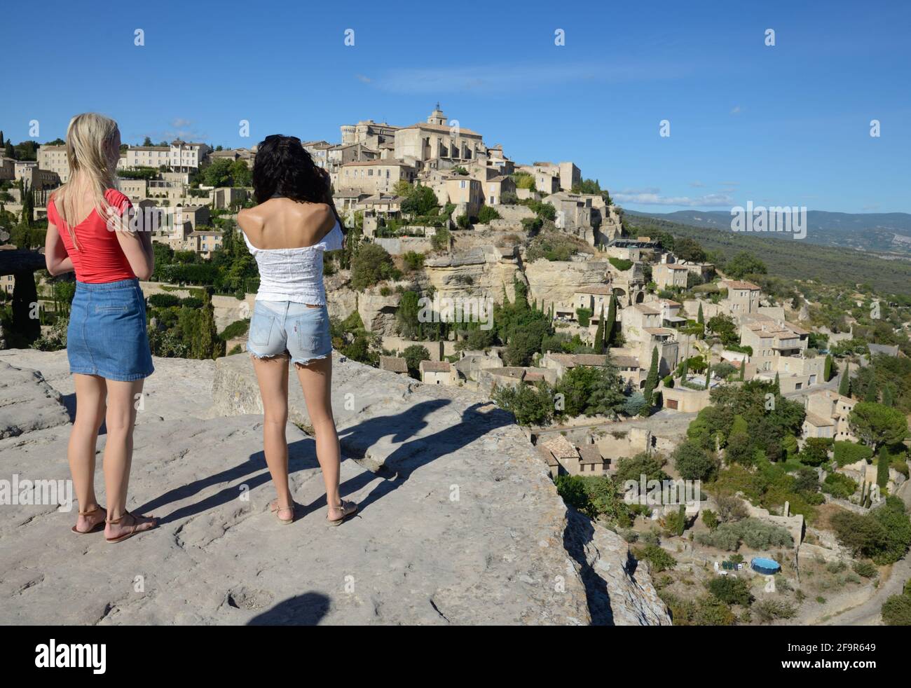 Quelques jeunes touristes féminins photographiant la vue sur le village à la mode de Gordes dans le Parc régional du Luberon Provence France Banque D'Images