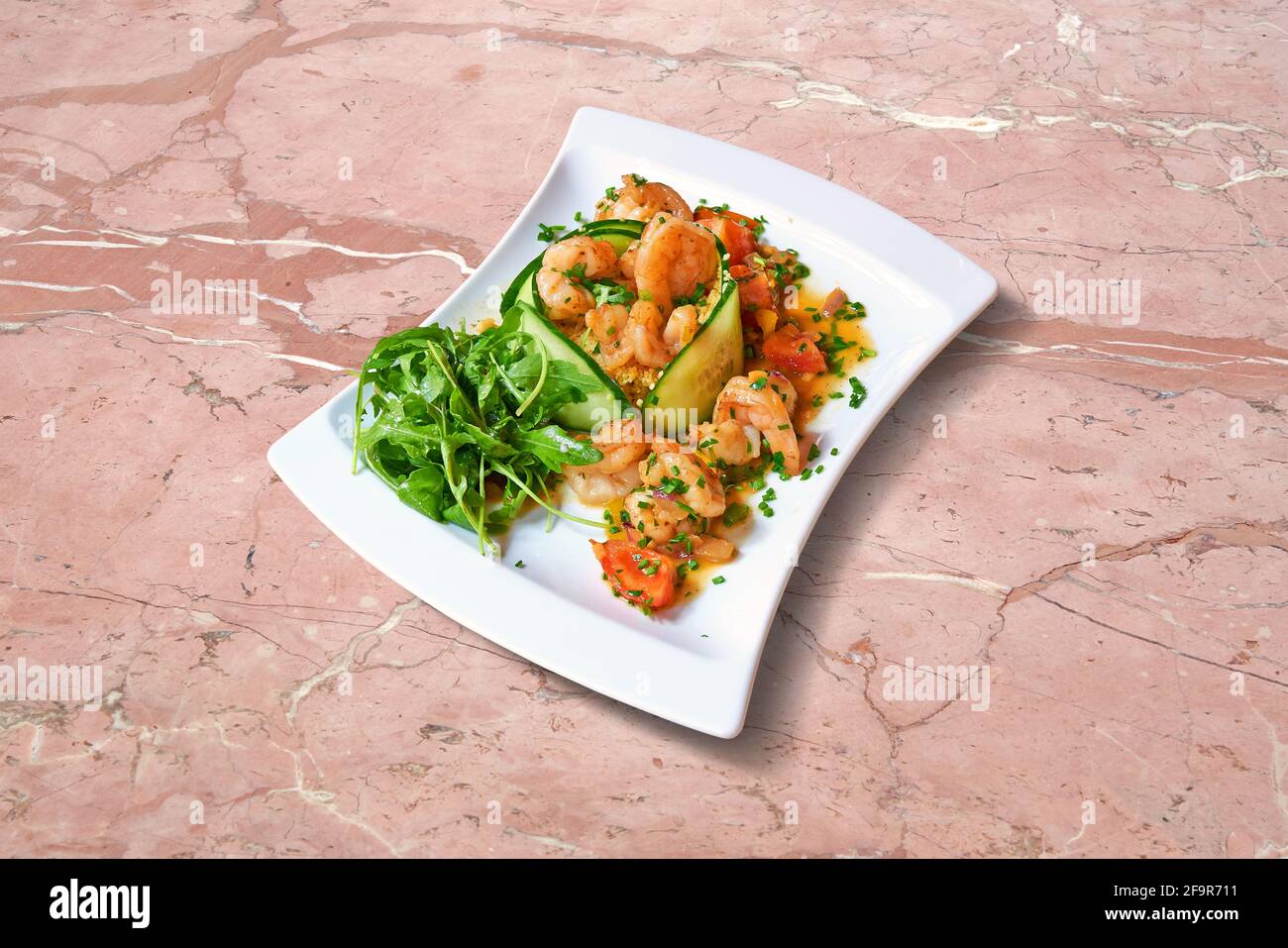 Cuisine de pub. Assiette de salade de scampis sur marbre rose Banque D'Images