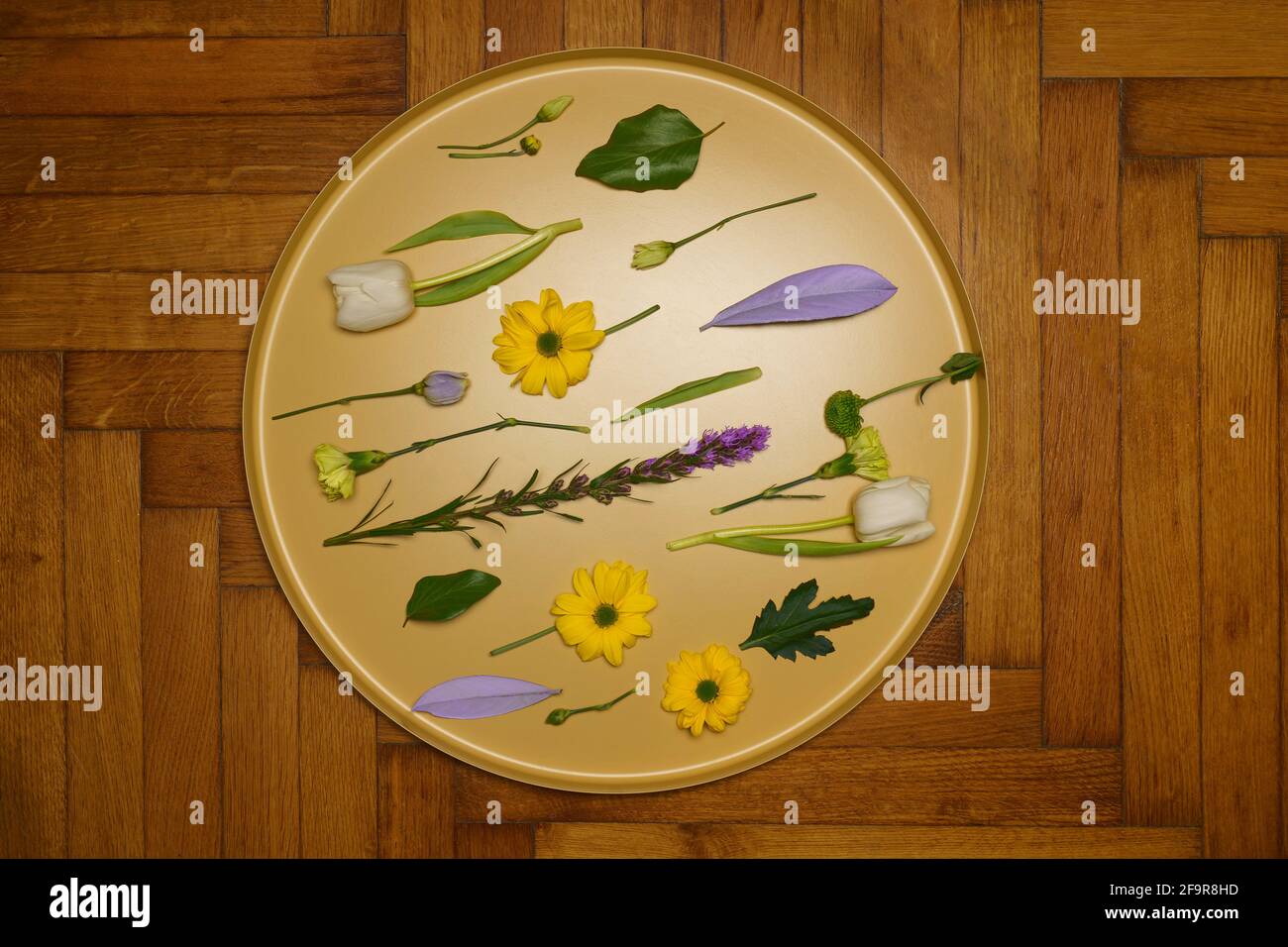 Plat déposer différentes fleurs sur plateau rond doré Banque D'Images