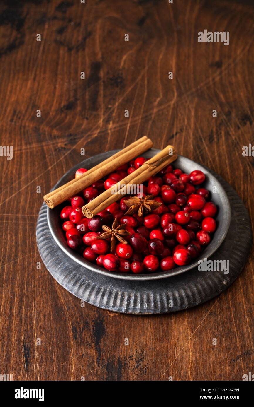 Ingrédients pour faire du vin chaud avec des canneberges. Orange, cannelle, canneberges, clous de girofle, anis et sucre. Décoration de Noël rétro Banque D'Images