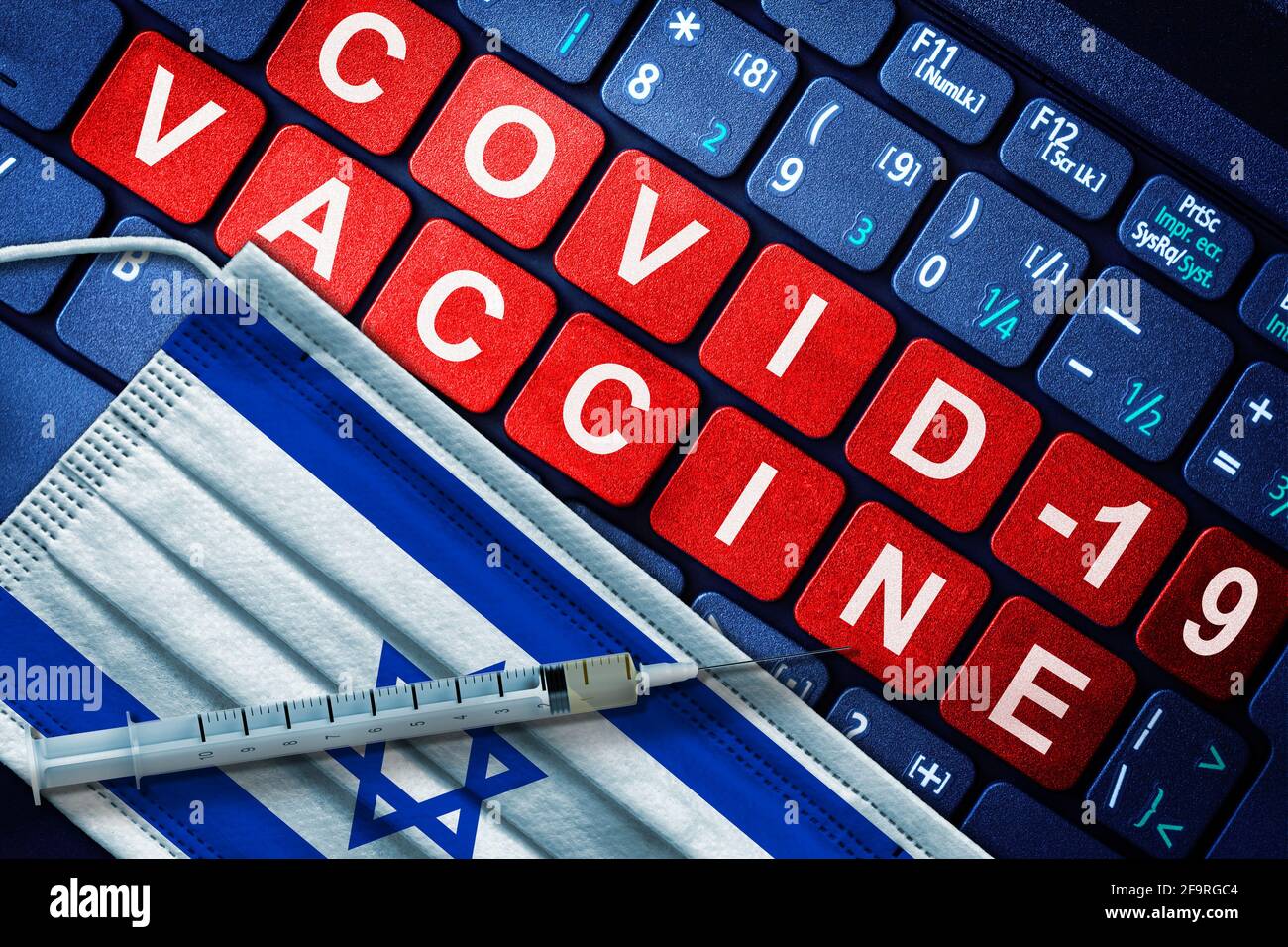 Vaccination COVID-19 en Israël avec seringue et masque facial avec drapeau israélien et message de vaccination sur clavier d'ordinateur. Concept de vaccination Covid Banque D'Images