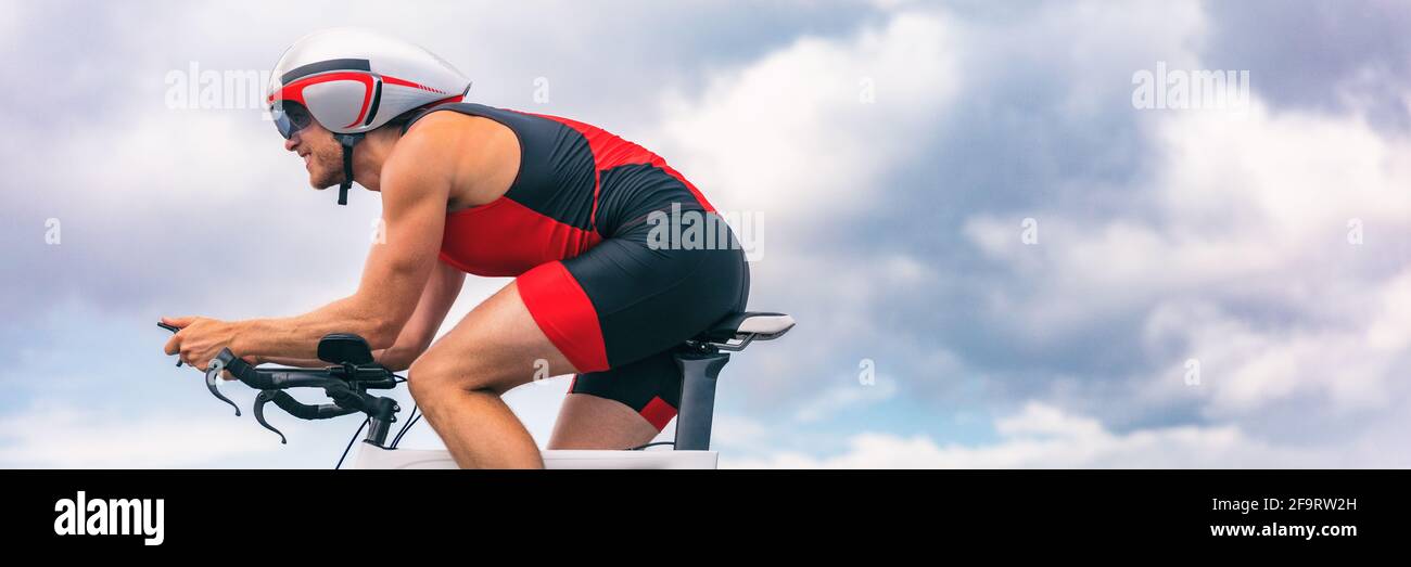 Triathlon cycliste homme vélo sur route avec casque d'essai de temps. Recadrage de bannière Panorama pour l'espace de copie du ciel Banque D'Images