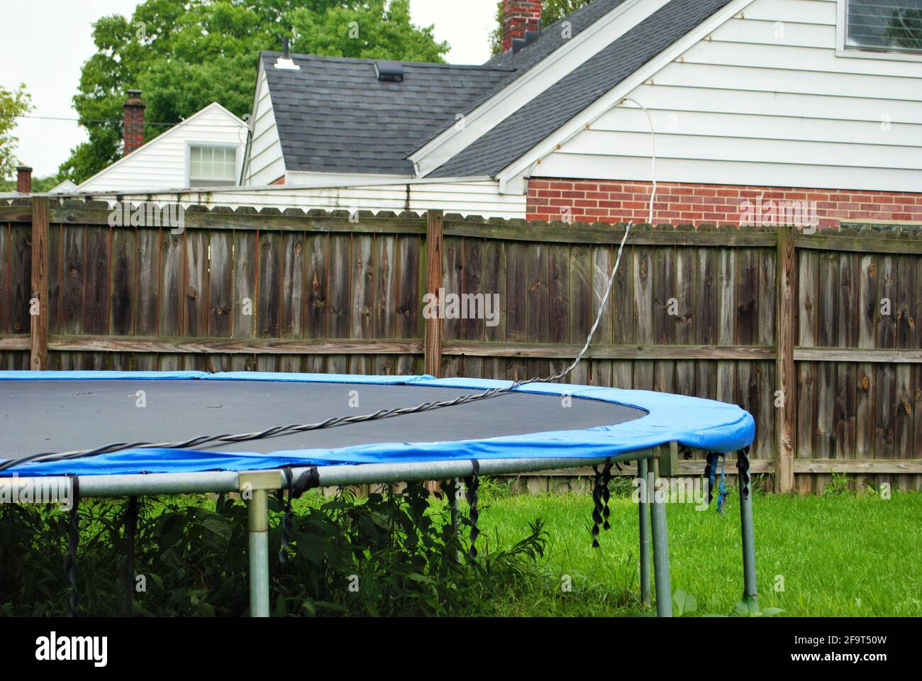 Une ligne électrique dangereuse, sous tension, drapée à travers la clôture  et le trampoline Photo Stock - Alamy