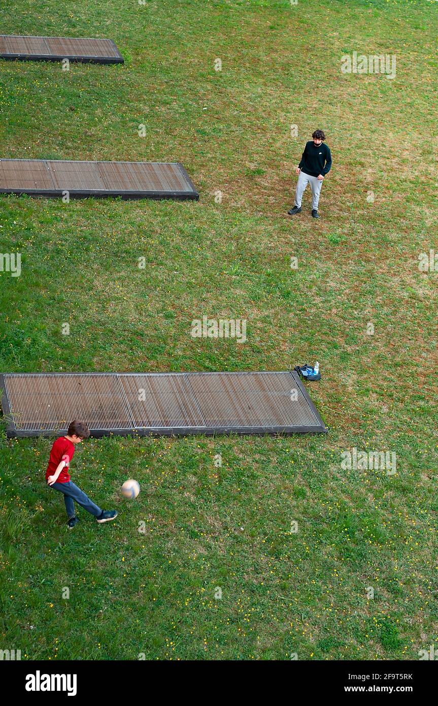 Les enfants jouent au football dans le parking au printemps après-midi Banque D'Images