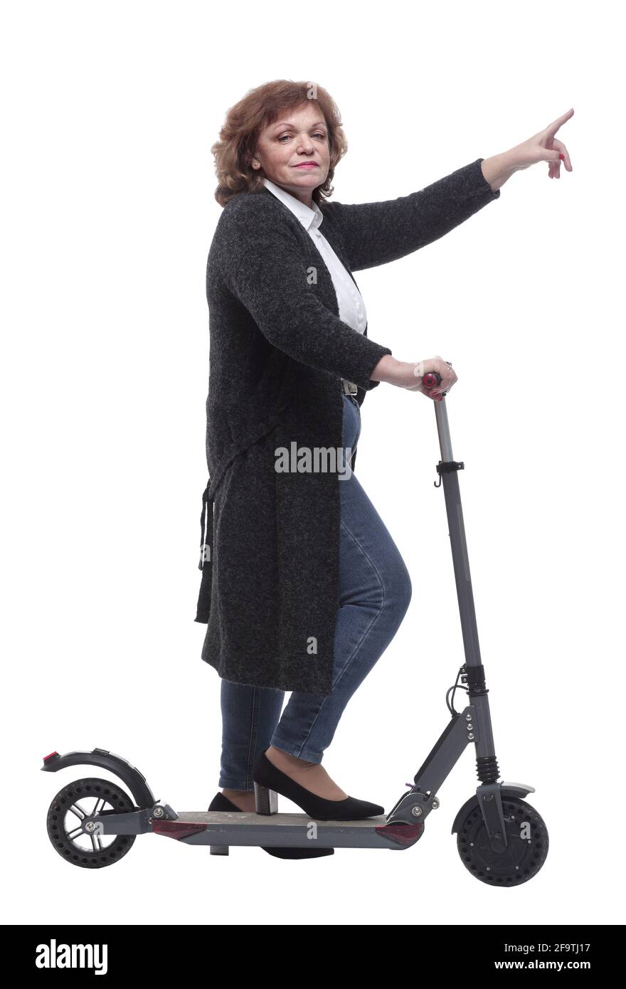 vue latérale. femme confiante avec un scooter électrique regardant la caméra Banque D'Images