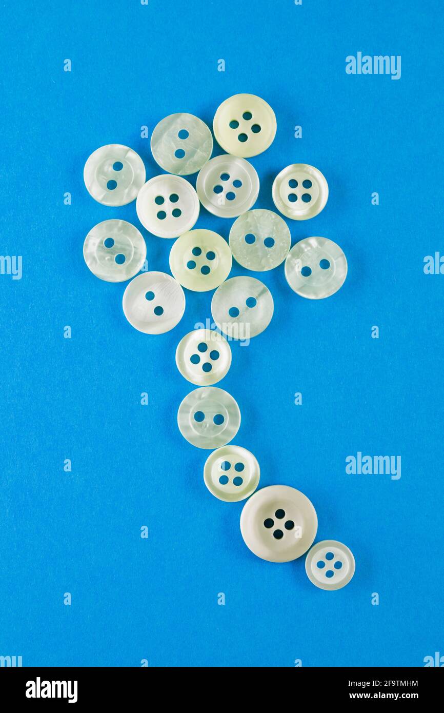 Boutons blancs sur fond bleu, divers boutons mis dans un forme de ballon Banque D'Images