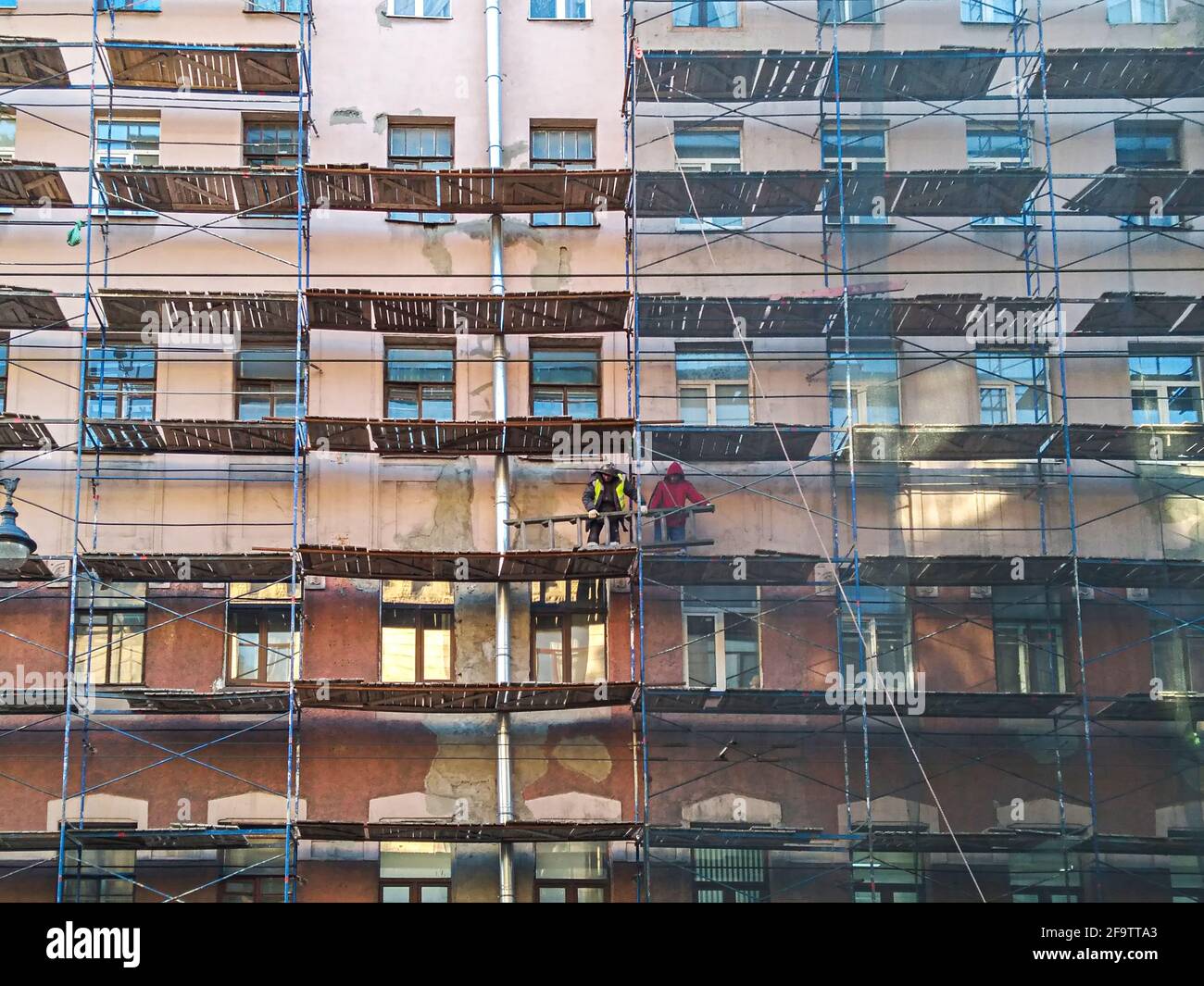 Ouvriers de construction sur l'échafaudage autour de l'ancien bâtiment de rénovation Banque D'Images