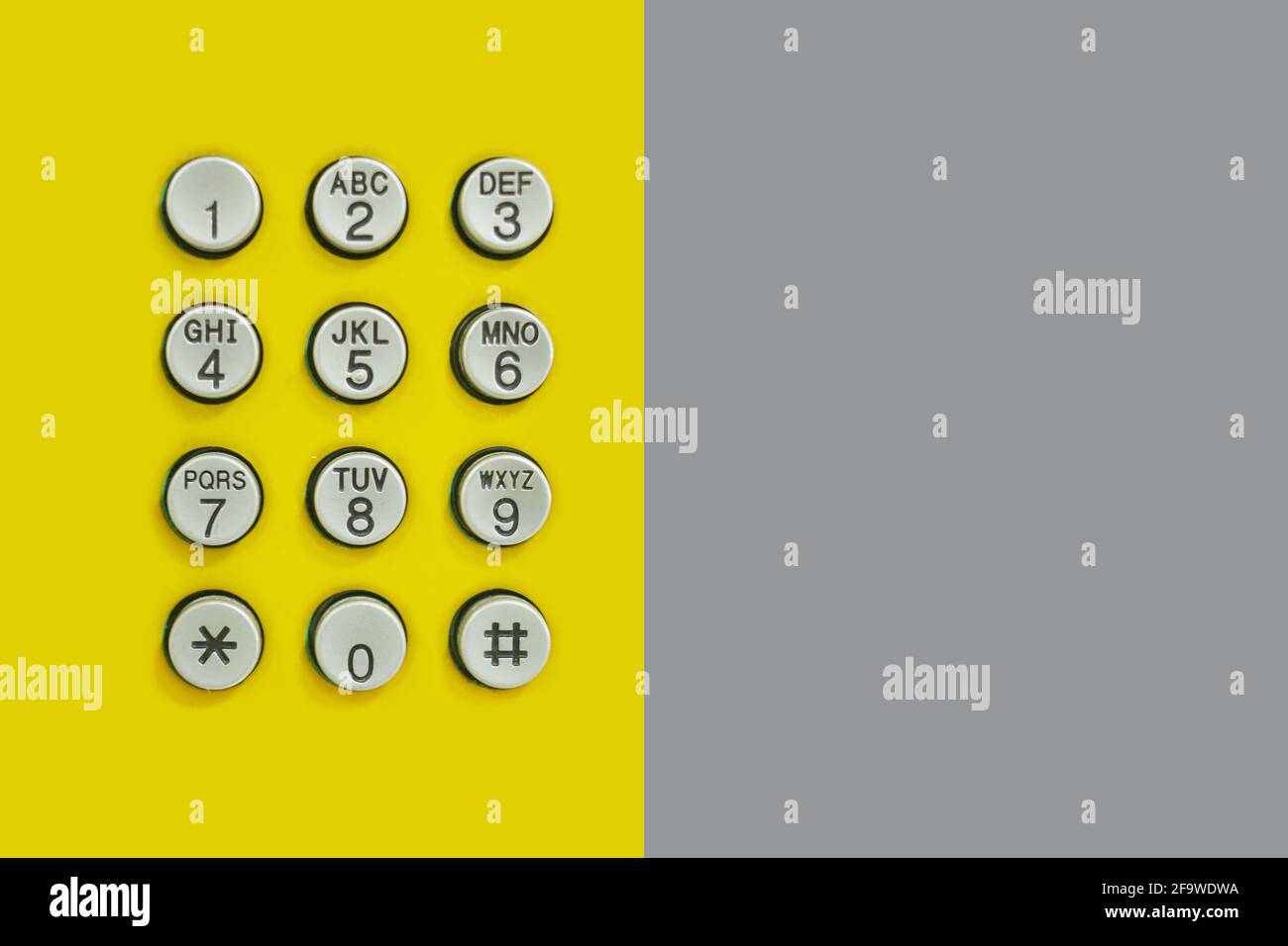 Clavier numérique du téléphone sur fond jaune et papier gris sur le côté pour le design en toile de fond technologique. Banque D'Images