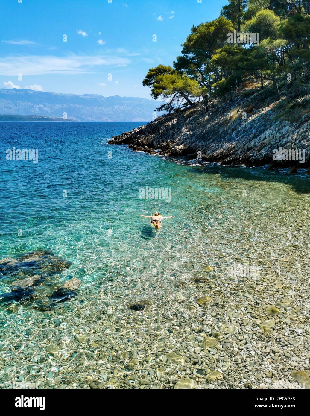 Personne sur un matelas pneumatique de détente sur la plage dans une crique cachée. Banque D'Images