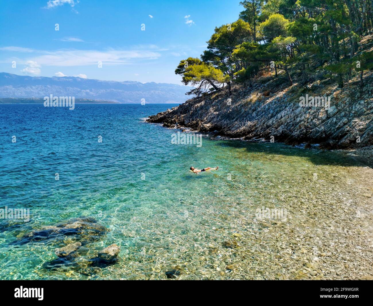 Personne sur un matelas pneumatique de détente sur la plage dans une crique cachée. Banque D'Images