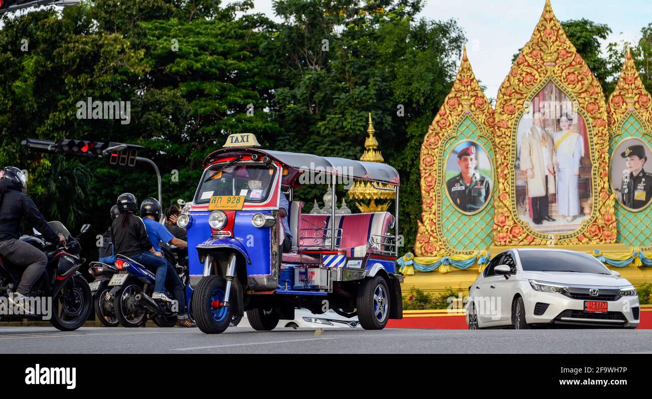 Bangkok, Thaïlande. 19 avril 2021. Un tuk tuk passe devant des portraits de la famille royale thaïlandaise dans le quartier de Dusit. Le taxi Tuk Tuk Tuk classique de renommée internationale de Thaïlande. Le taxi à trois roues est un mode populaire de transport local sans compteur pour les habitants et les touristes, le tarif est négocié en fonction de la distance. Le pousse-pousse motorisé thaïlandais est un symbole de la nation. Crédit : SOPA Images Limited/Alamy Live News Banque D'Images