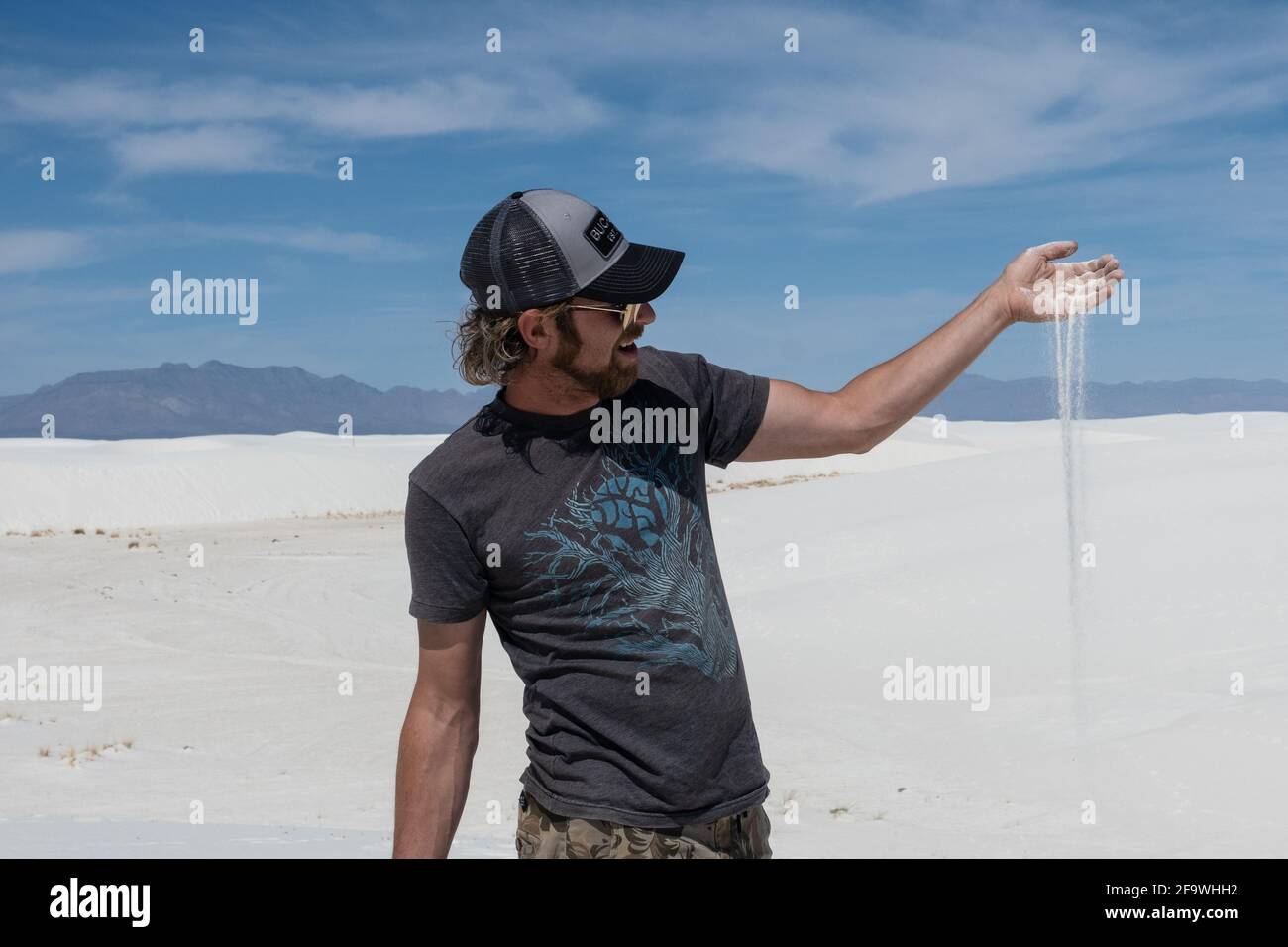 Un touriste tient un peu de gypse dans sa main au monument national de White Sands au Nouveau-Mexique. Banque D'Images