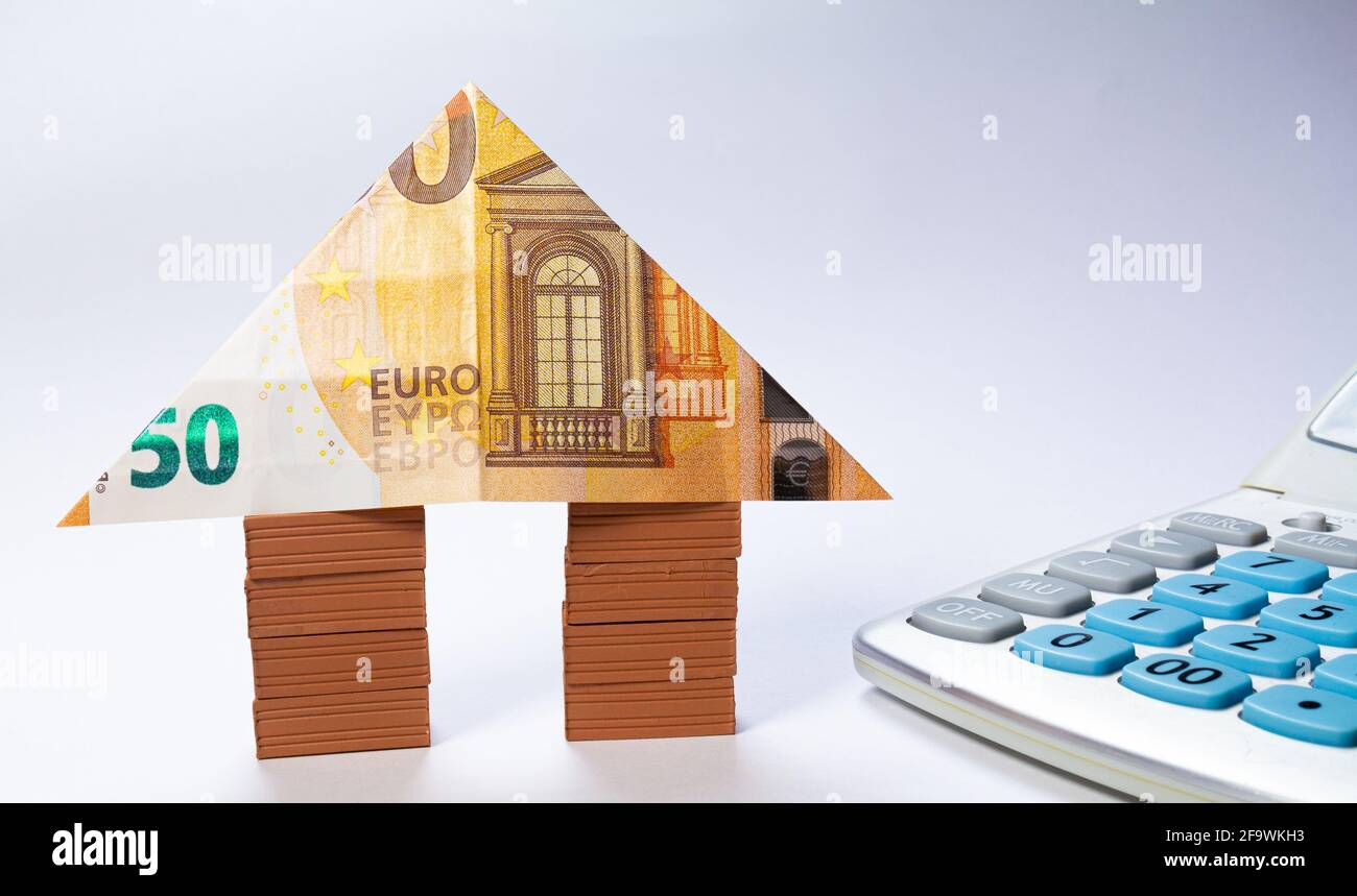Maison faite de piles de briques avec une note de 50 euros comme toit. Immobilier de prêt à la maison pour le concept d'hypothèque. Banque D'Images