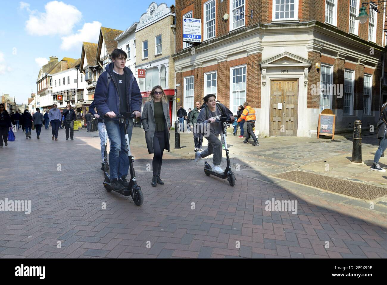 Canterbury, Kent, Royaume-Uni. Deux garçons sur DES SCOOTERS ÉLECTRIQUES D'OISEAU dans Canterbury High Street Banque D'Images