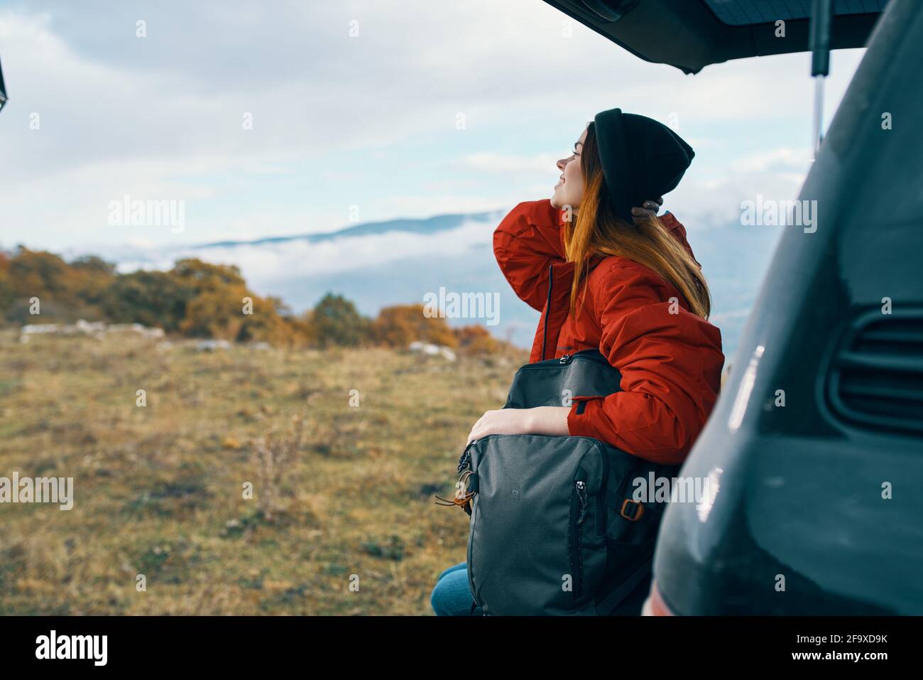 une femme voyage dans les montagnes avec un sac à dos sur elle arrière paysage automne chaud vêtements modèle Banque D'Images