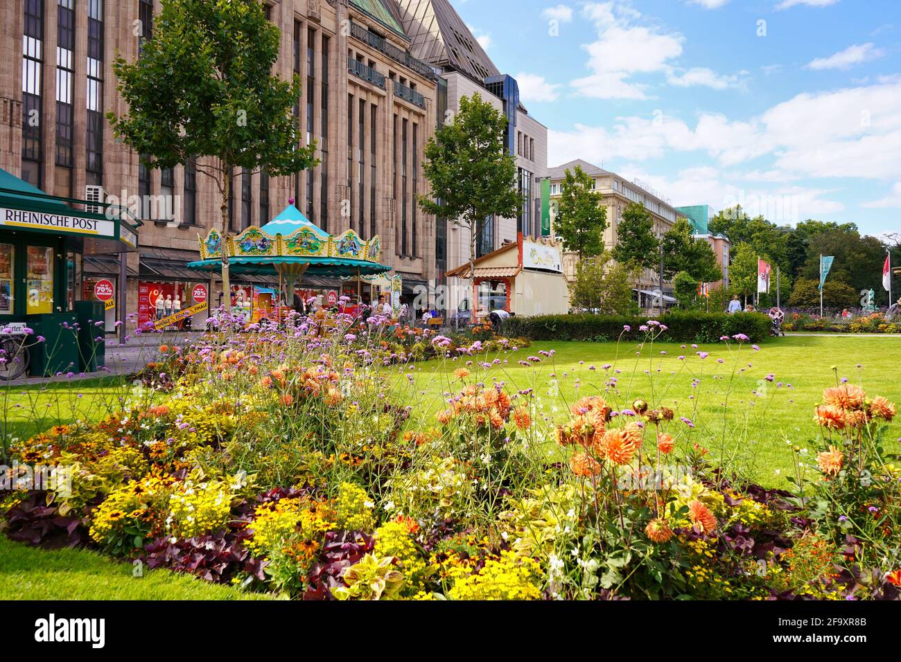 Vue panoramique sur Corneliusplatz dans le centre-ville de Düsseldorf avec carrousel nostalgique devant le bâtiment du grand magasin 'Kaufhof', érigé en 1909. Banque D'Images