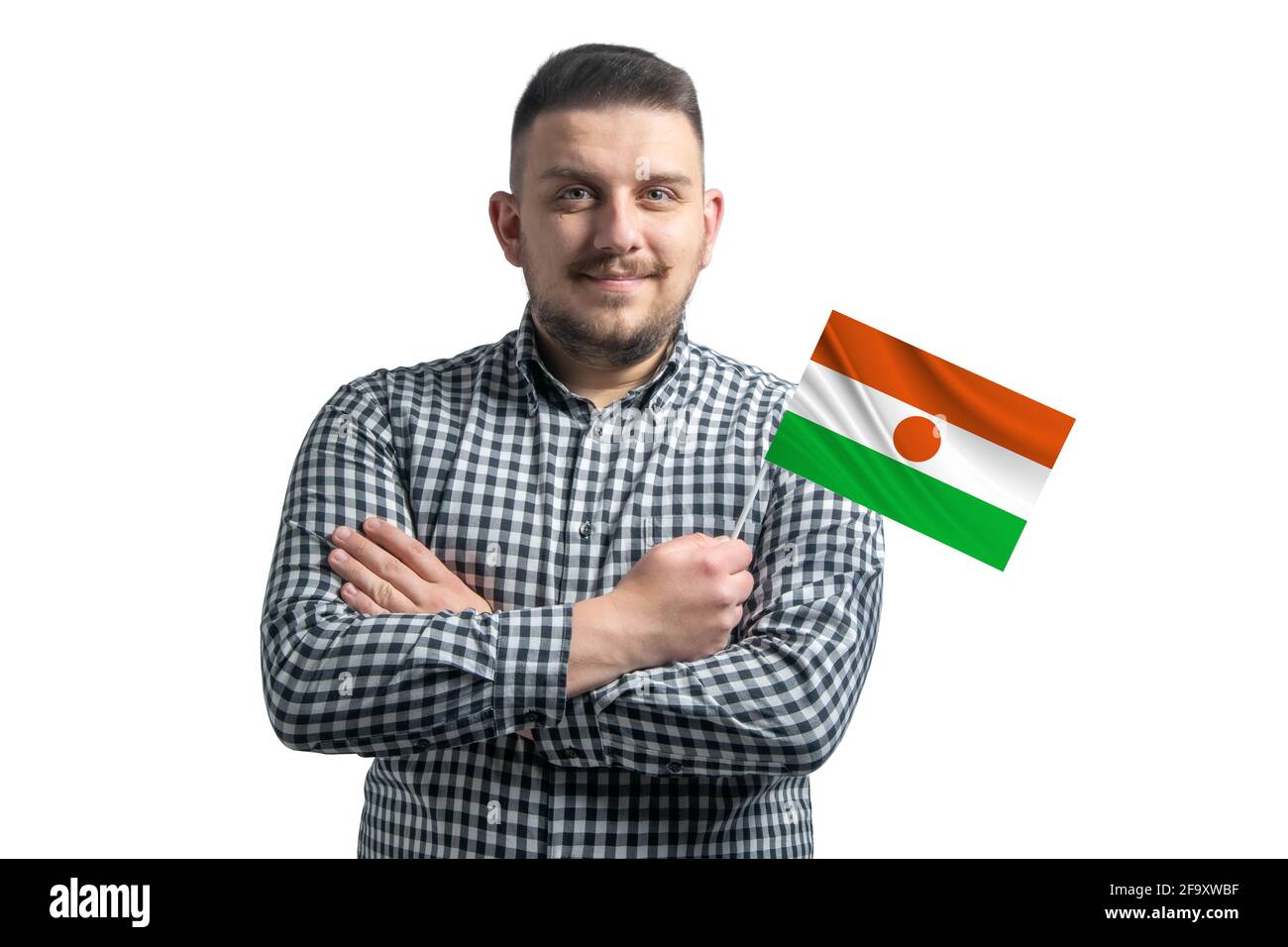 Homme blanc tenant un drapeau du Niger souriant confiant avec des bras croisés isolés sur un fond blanc. Banque D'Images