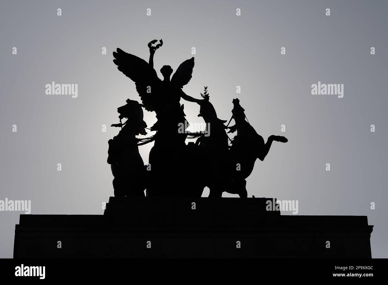 Londres, Royaume-Uni - 20 avril 2021 : les thats quadriga en bronze sont installés au sommet de Wellington Arch, à Hyde Park Corner, silhouetés contre le soleil du matin. Banque D'Images