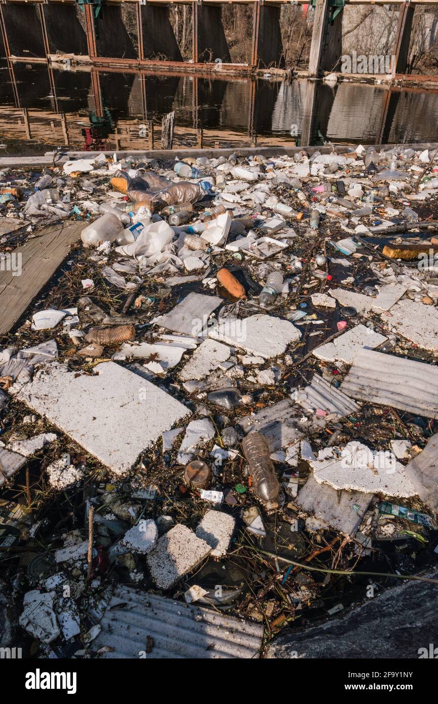 Les ordures et les déchets se ramassent dans la rivière urbaine, causant une sauvegarde de la pollution. Banque D'Images