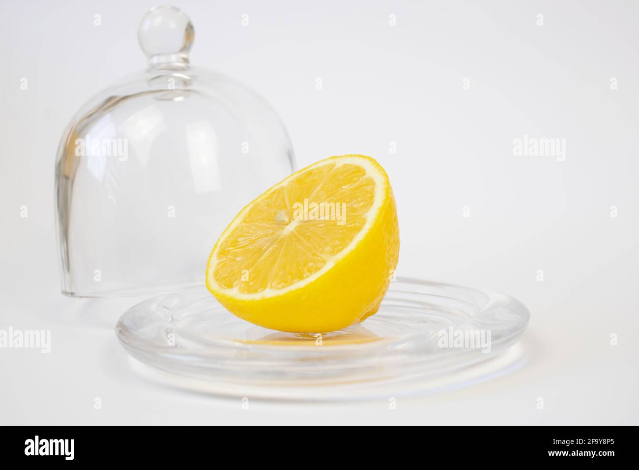 Un demi de citron à côté de la cloche en verre. Banque D'Images