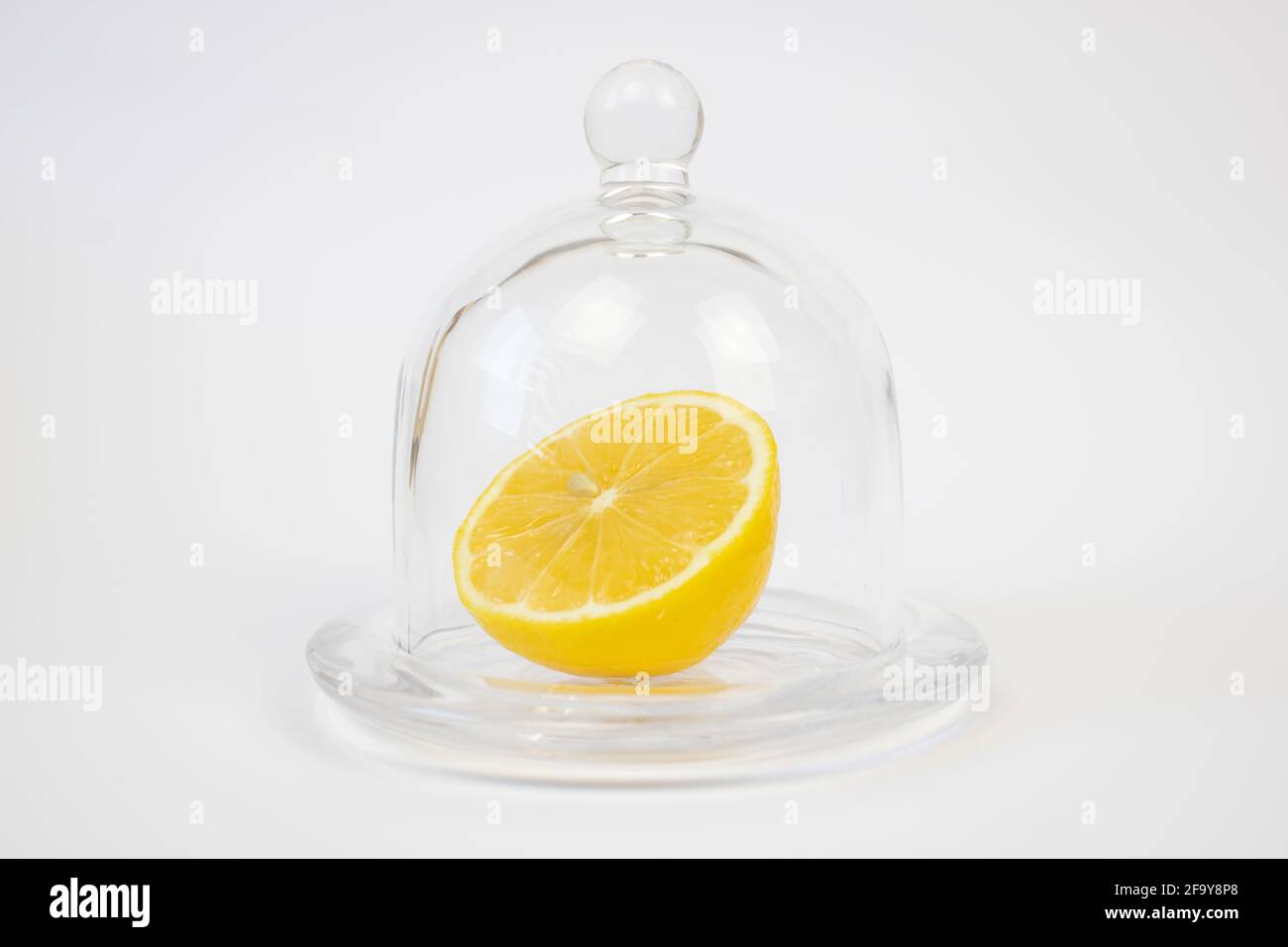 Un demi de citron à côté de la cloche en verre. Banque D'Images