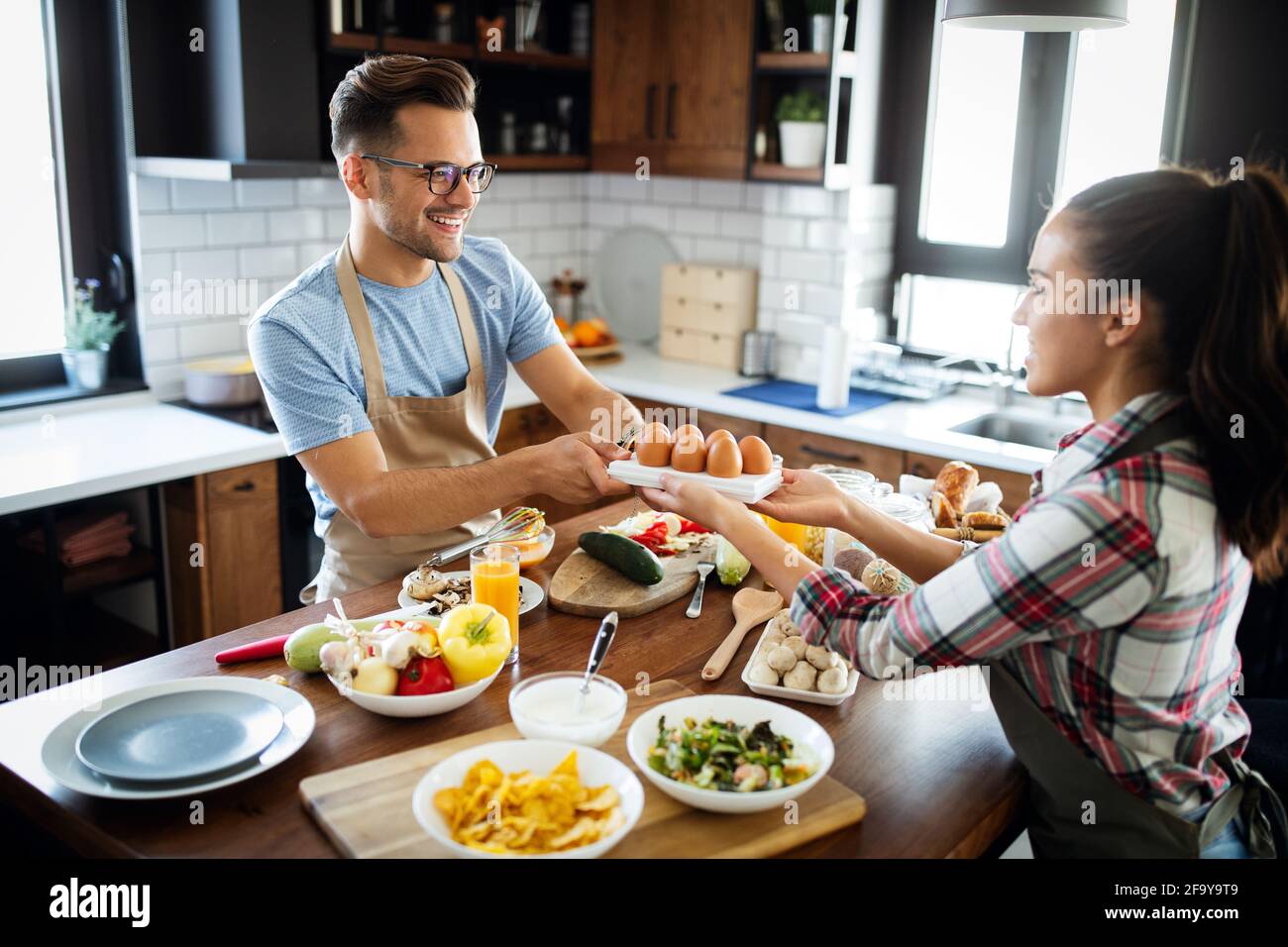 Un jeune couple heureux s'amuse dans une cuisine moderne tout en se préparant produits frais Banque D'Images