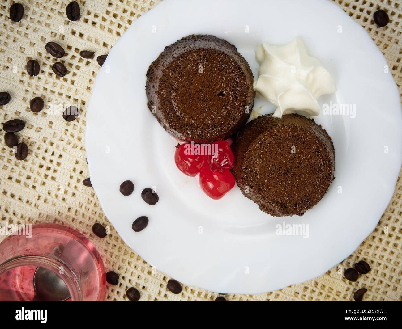 Crème caramel dessert ou café Flan a avec cerise et une cuillère en métal sur une assiette décorée de grains de café Banque D'Images