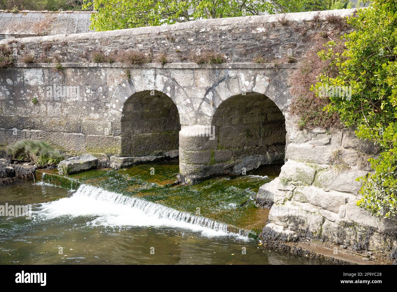 La rivière Helford coule sous un vieux pont en pierre à Gweek, dans les Cornouailles Banque D'Images