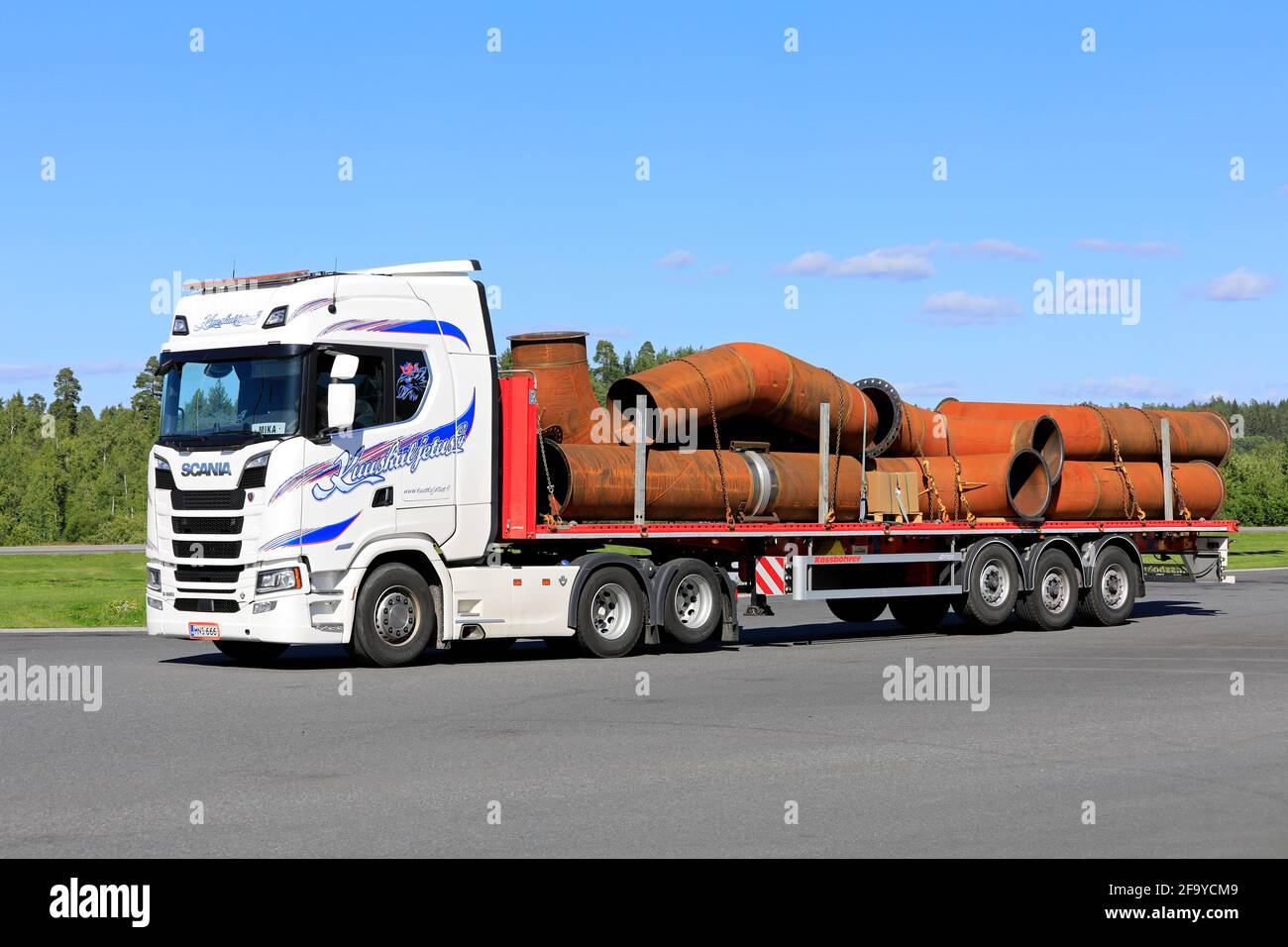 Le camion White Scania S 580 Kuuskuljetus Oy transporte des tuyaux industriels sur une remorque à plateau le jour de l'été. Forssa, Finlande. 31 juillet 2020. Banque D'Images