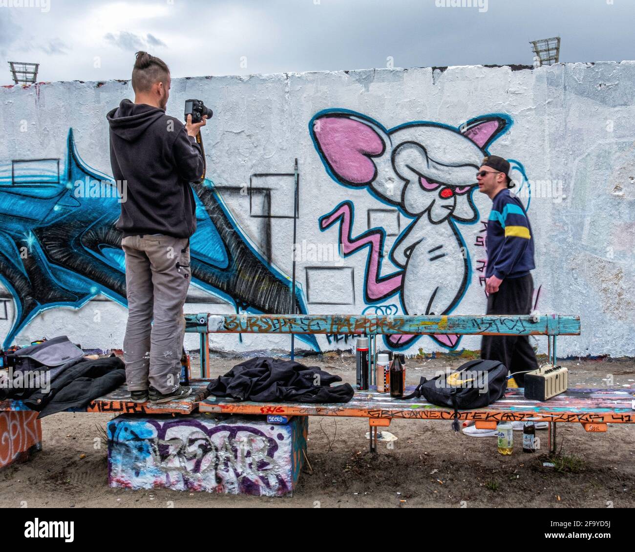 Un jeune artiste de rue peint de nouveaux travaux d'art de rue sur le mur à Mauerpark, Prenzlauer Berg, Berlin, Allemagne Banque D'Images