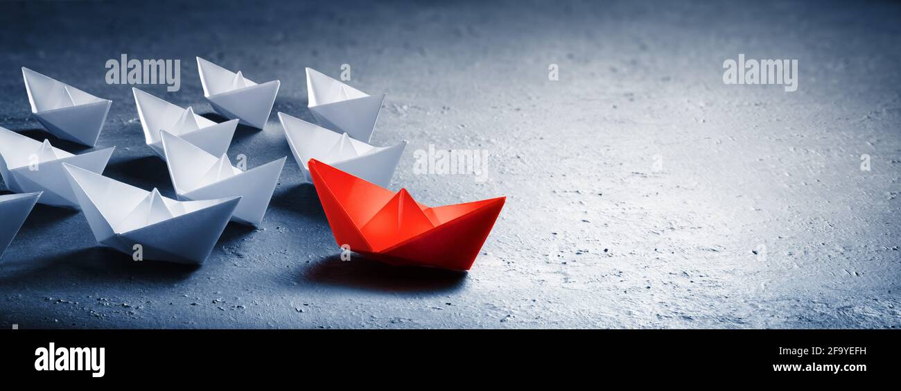 Red leader Paper Boat Leading Group of Paper Boates Banque D'Images