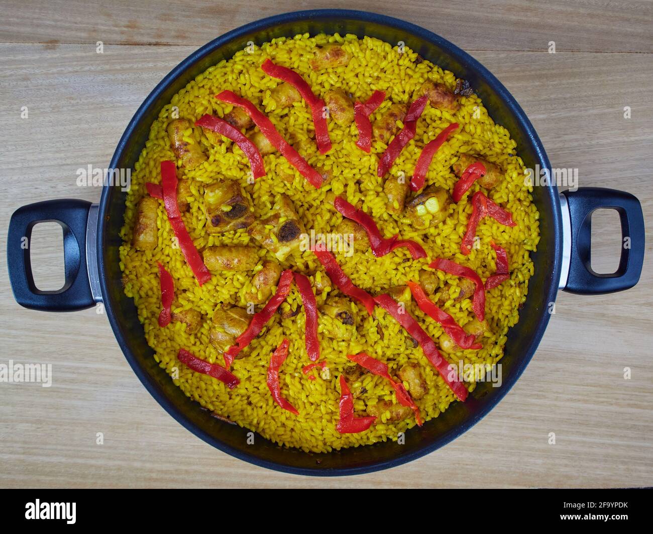 Paella traditionnelle espagnole de fruits de mer avec saucisses de porc, côtes de porc et poivrons rouges dans une poêle à frire. Vue de dessus Banque D'Images