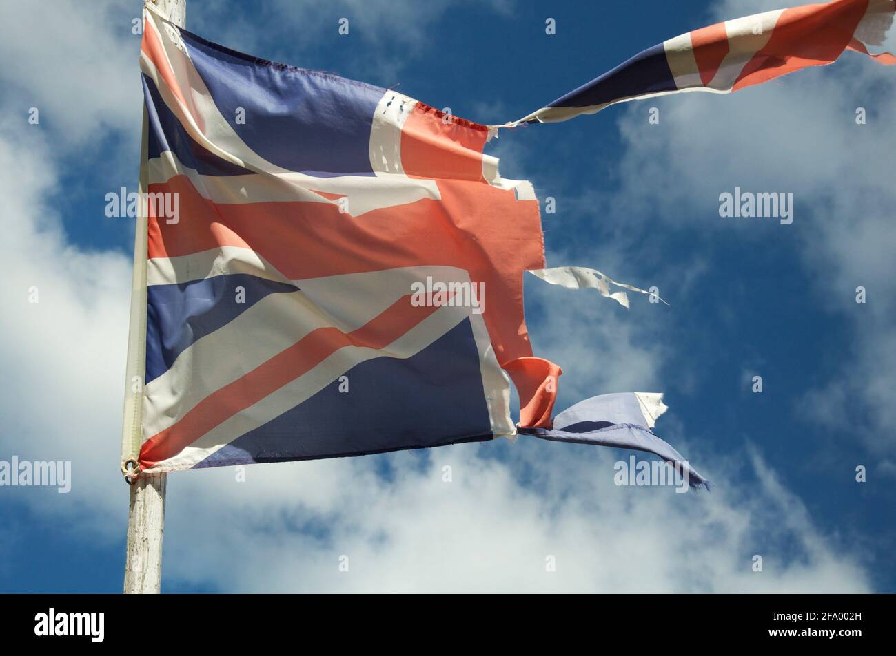 Vieux et défraîchi. Le drapeau de l'Union du Royaume-Uni a flatté et déchiré, flatté et battant dans le vent contre le ciel. Angleterre, Royaume-Uni, Grande-Bretagne. Banque D'Images