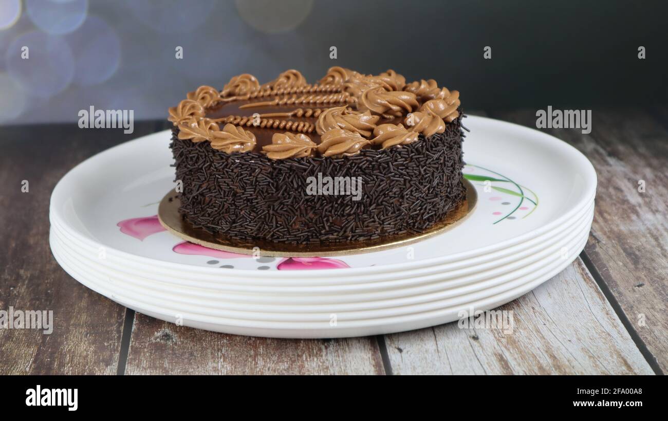 Gros plan de gâteau brun chocolat isolé sur fond de bois Banque D'Images