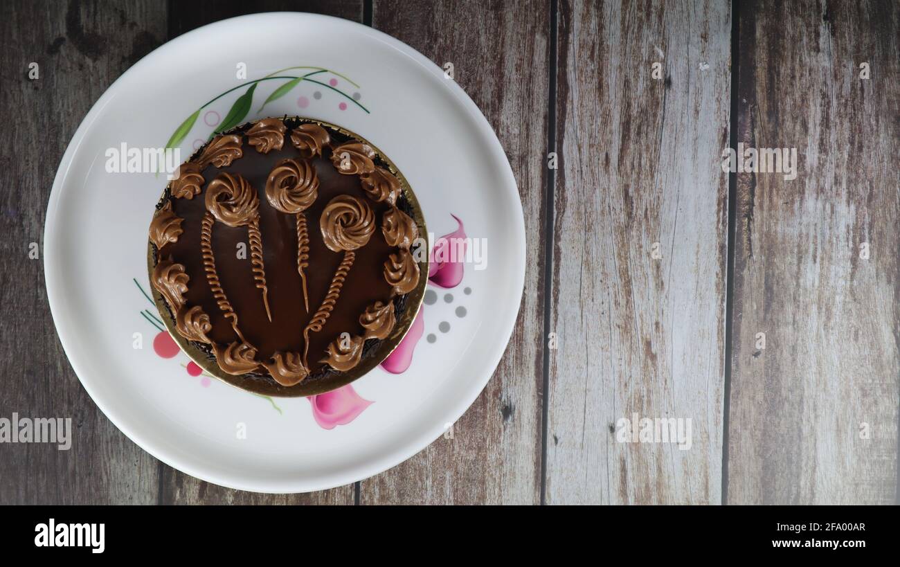 Gros plan de gâteau brun chocolat isolé sur fond de bois Banque D'Images