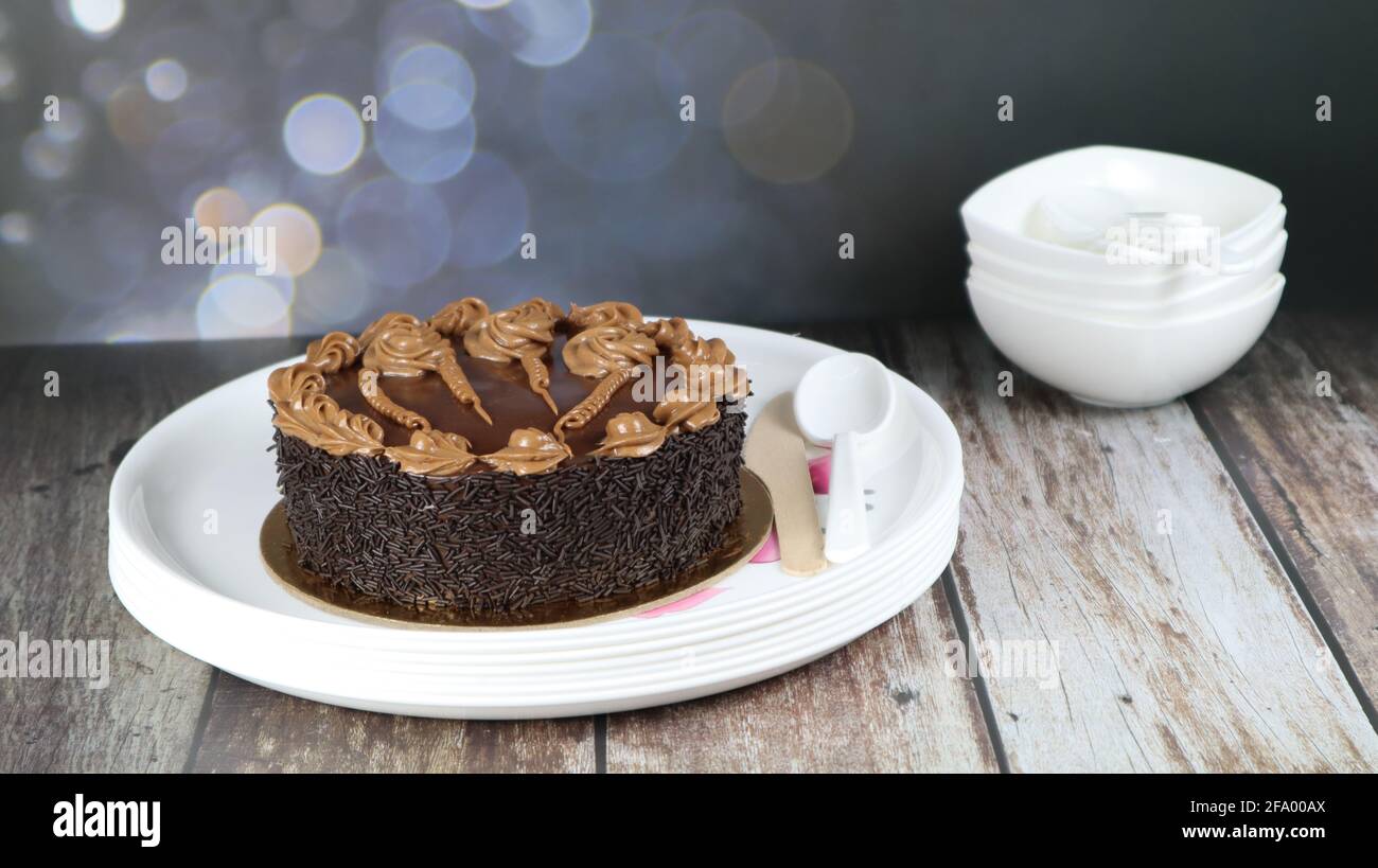 Gros plan de gâteau brun chocolat isolé sur fond de bois Banque D'Images