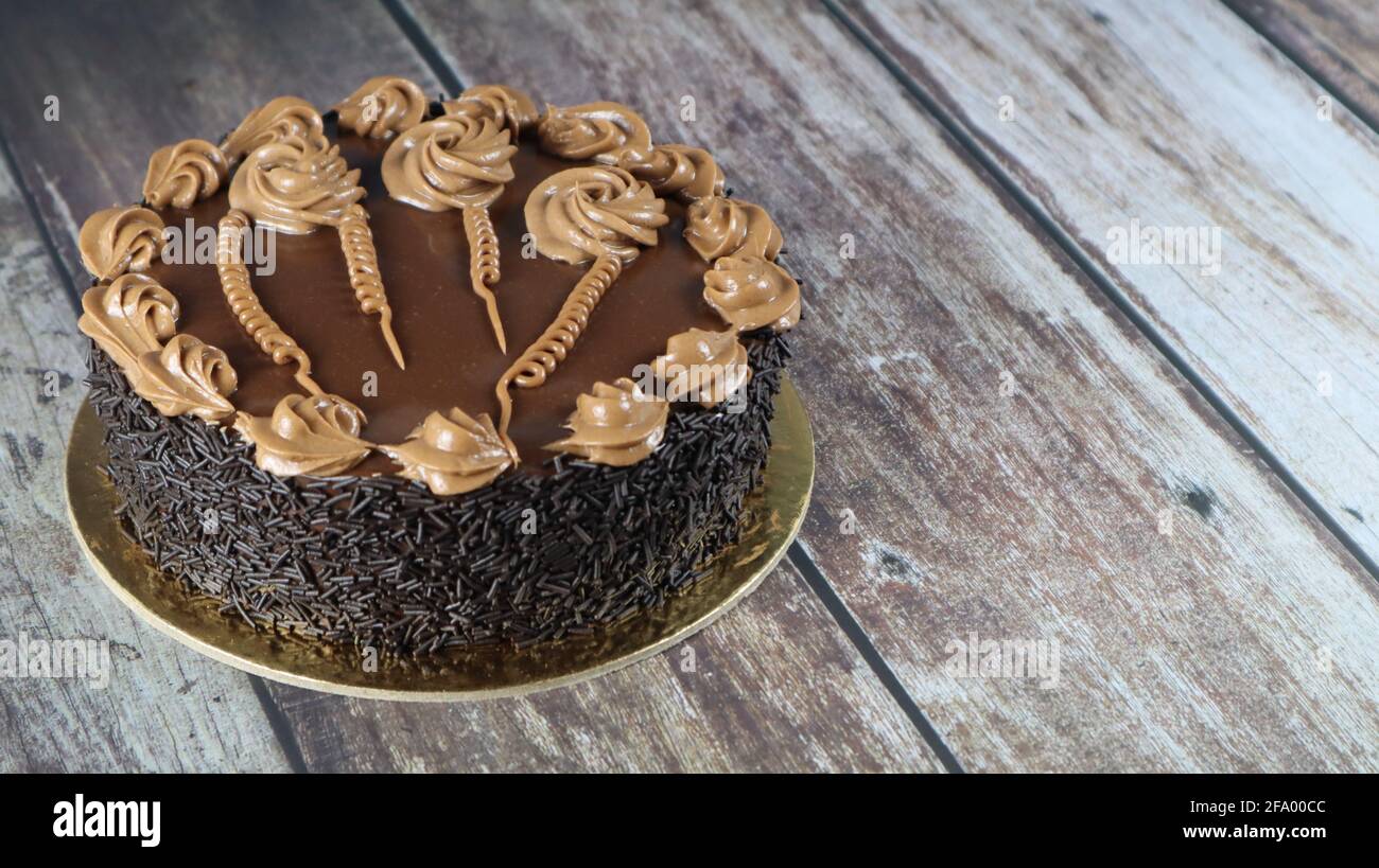 Gros plan de gâteau brun chocolat isolé sur fond de bois Banque D'Images