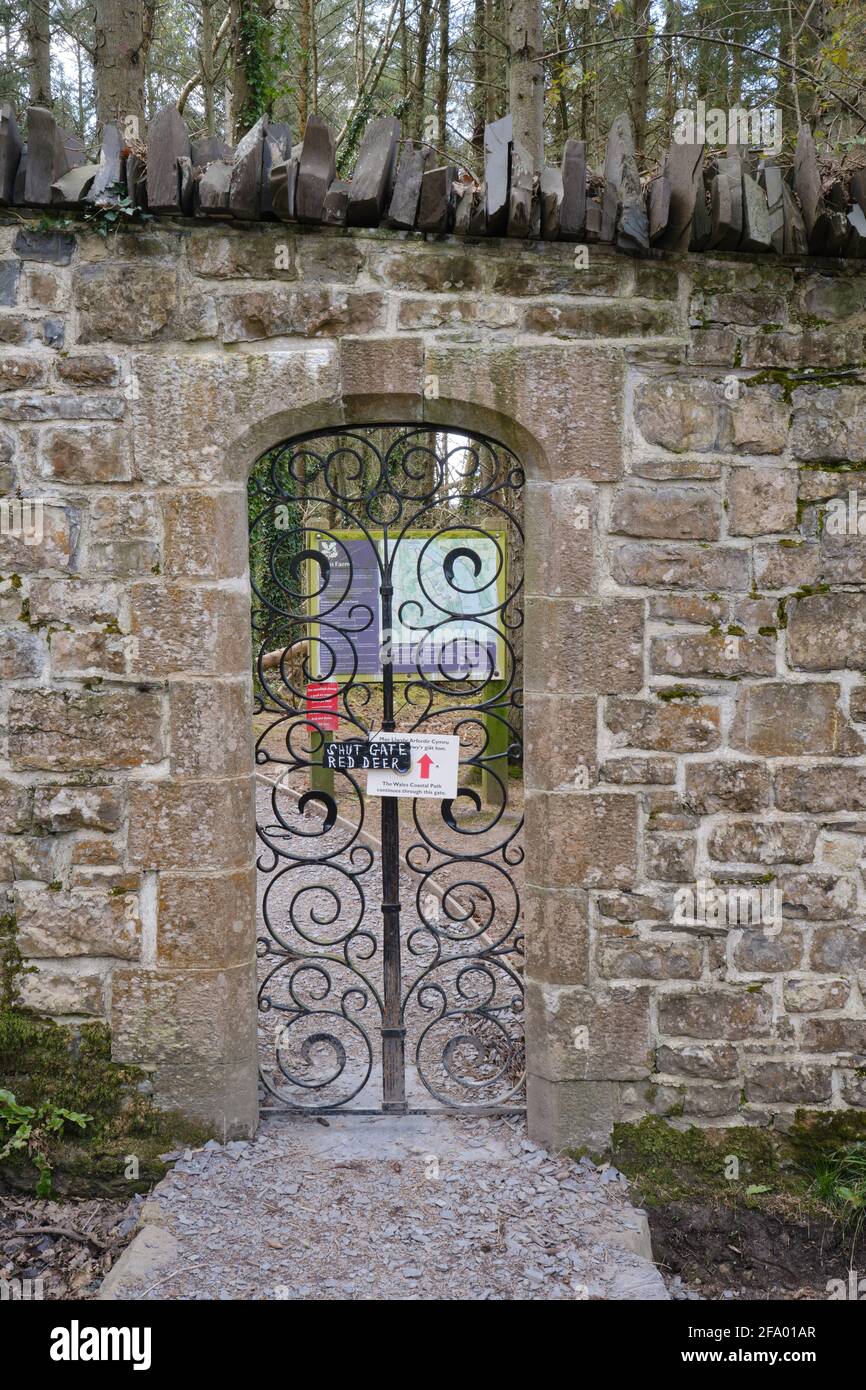 Une porte en fer très ornée donne accès au Wales Coast Path et à la vie sauvage et à la promenade dans les bois de Glan Faenol. Banque D'Images