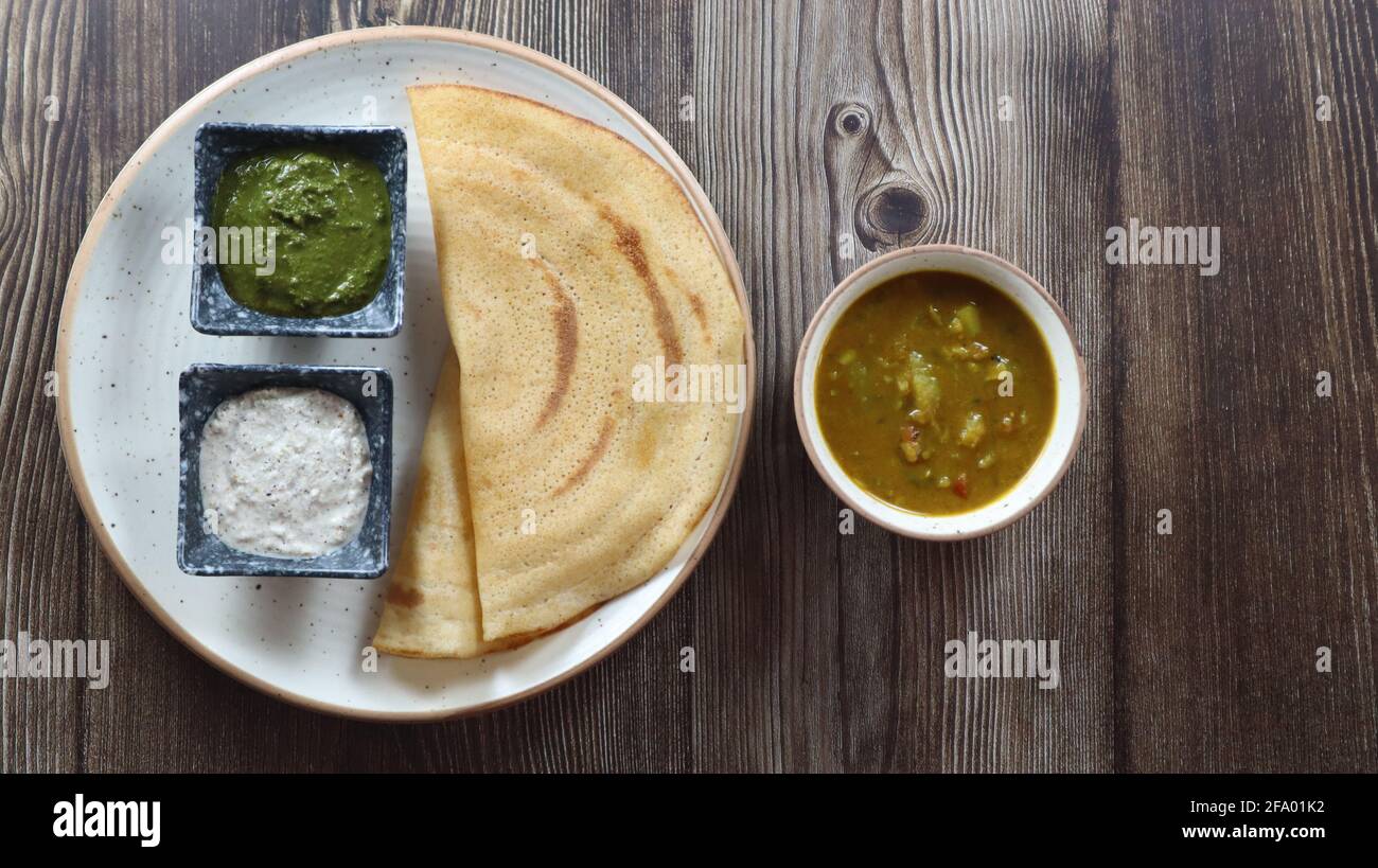 DOSA (Thin Pancake ou crêpe,) est un repas indien du Sud servi avec sambhar et chutney de noix de coco (sauce) isolé dans un fond différent, style différent Banque D'Images