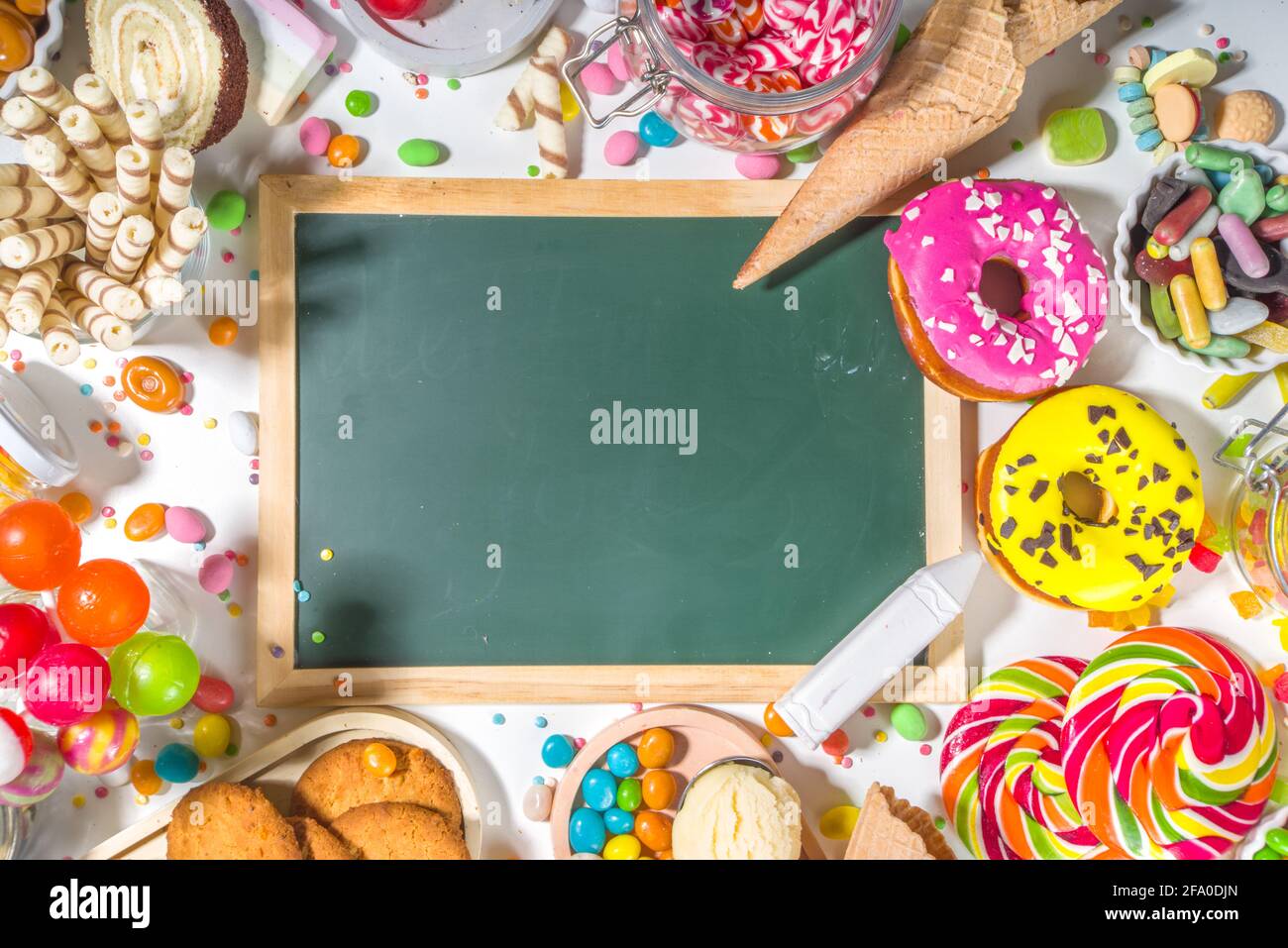 Sélection de bonbons colorés. Assortiment de bonbons, chocolats, beignets, biscuits, sucettes, vue de dessus de crème glacée sur fond blanc Banque D'Images